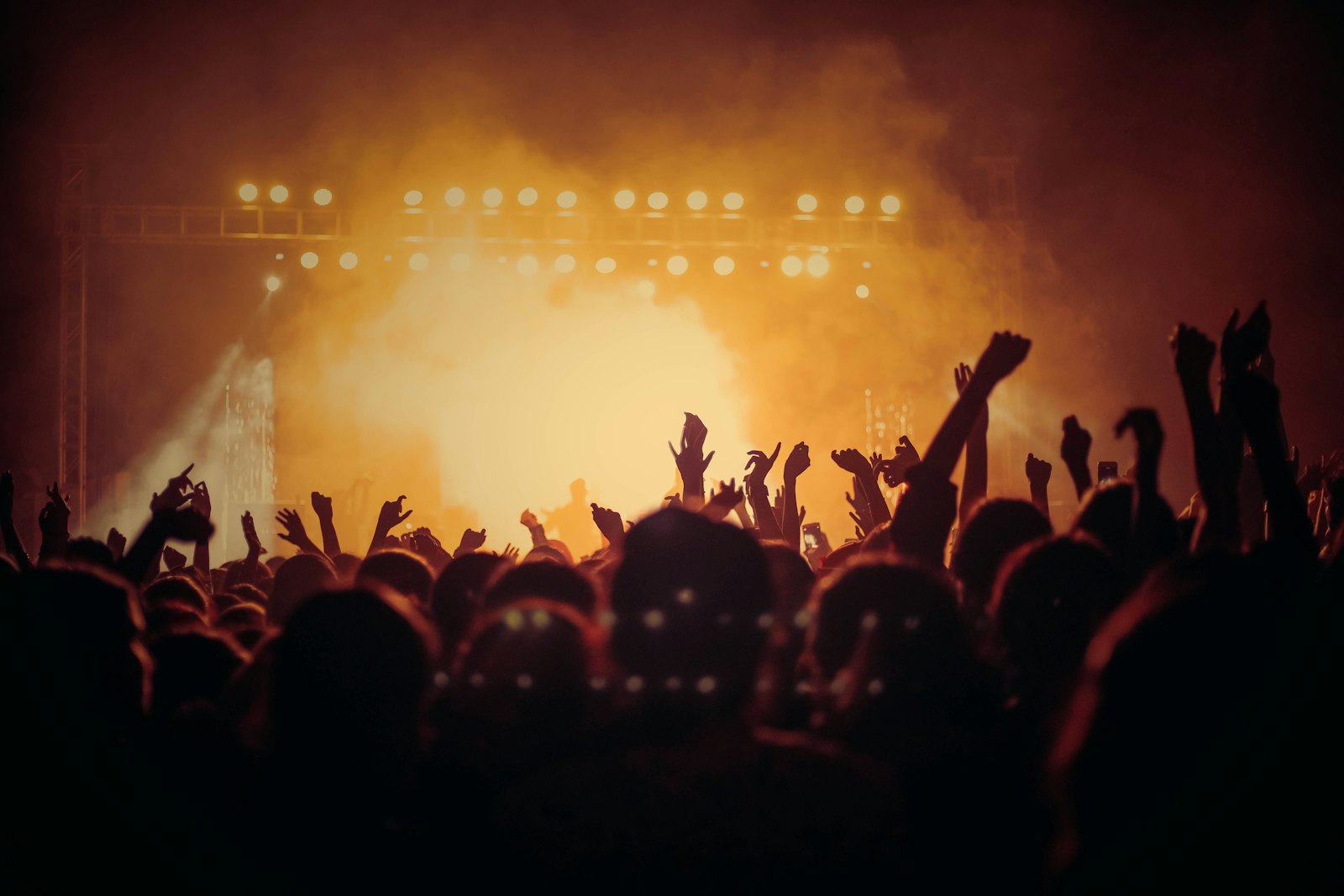 Público frente a un escenario iluminado durante un evento en vivo